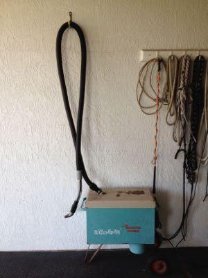 horse vacuum and hose hung high on the wall
