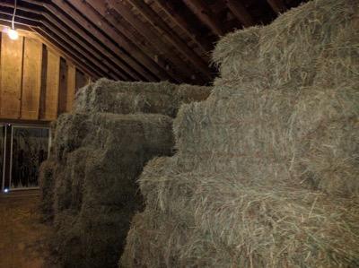two large stacks of hay in hay loft