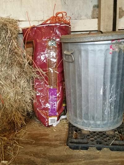 metal garbage can and a bag of feed