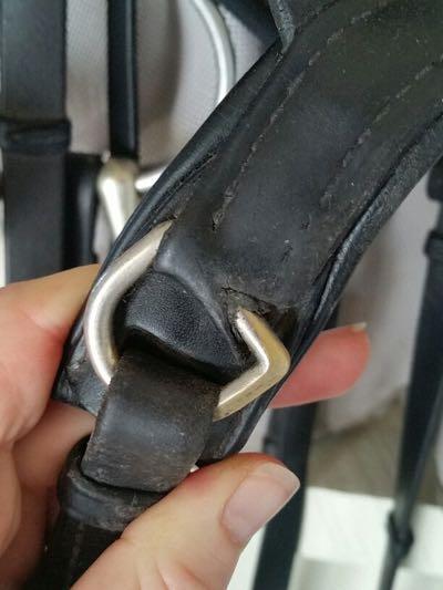 torn leather on a black dressage bridle