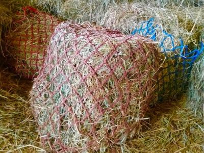 three small hole hay nets in a hay loft