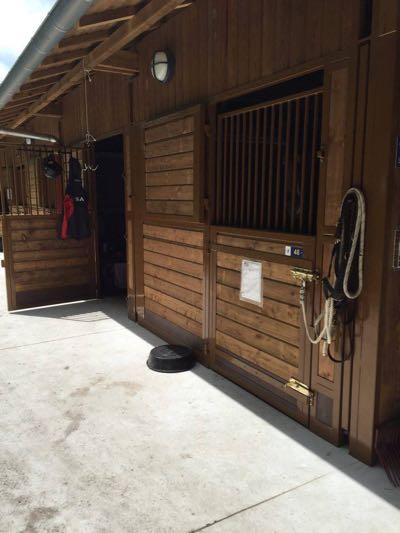 fancy brown wood stall at a horse show